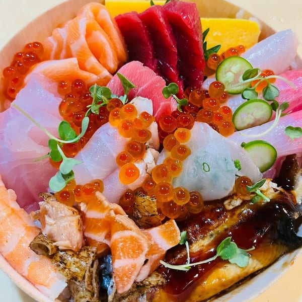 Close-up of a colorful chirashi bowl from Sushi Hatsune, featuring various sashimi, roe, and garnishes.